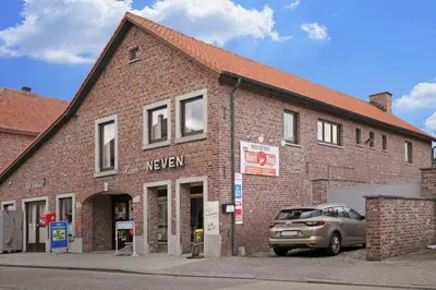 a car parked in front of a brick building at Bij Suus onder de wol in Borgloon