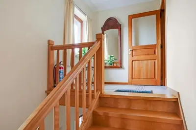 a staircase with a mirror and a wooden door at Bij Suus onder de wol in Borgloon