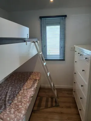 a bedroom with a bunk bed and a ladder at Vakantie-Chalet Camping GOOLDERHEIDE met seizoensgebonden zwembad in Bocholt