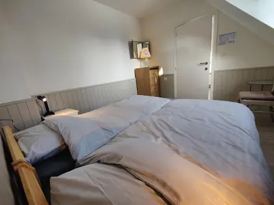 a bedroom with two beds with sheets at Sluizen aan de Jeker in Tongeren