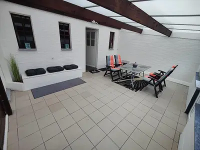 a patio with a table and chairs and a building at Sluizen aan de Jeker in Tongeren
