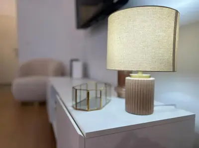 a lamp on a white table with a couch at Havre des Anges - Pont de Fragnée, Guillemins in Liège