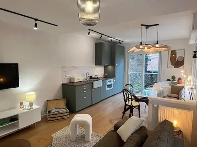 a living room and kitchen with a couch and a table at Havre des Anges - Pont de Fragnée, Guillemins in Liège
