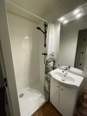 a white bathroom with a sink and a shower at Pipowagen de Zwaan in Hoge Kempen nabij Maastricht in Lanaken