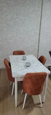 a white table with brown chairs and a white counter top at Au pied du théâtre in Verviers