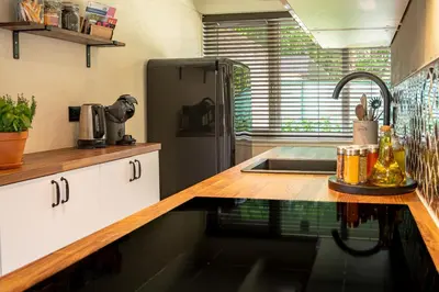 a kitchen with a sink and a refrigerator at Boshuisje Rekem - Silas in Lanaken