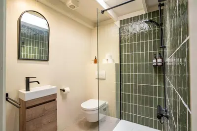 a bathroom with a shower and a toilet and a sink at Boshuisje Rekem - Silas in Lanaken