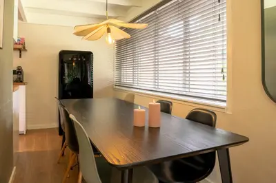 a dining room table with chairs and a window at Boshuisje Rekem - Silas in Lanaken