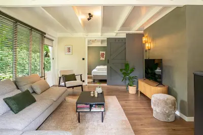 a living room with a couch and a table at Boshuisje Rekem - Silas in Lanaken