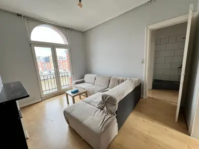 a living room with a couch and a large window at Le Minimum in Liège