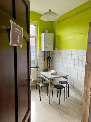a kitchen with a table and chairs in a room at Le Minimum in Liège