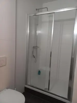 a bathroom with a glass shower with a toilet at Casa Barata in Riemst