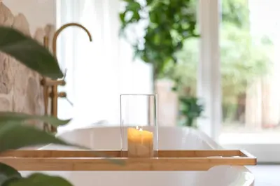 a candle sitting on top of a wooden tray at Ontspan huisje: wellness in de natuur in Lanaken