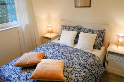 a bedroom with a bed with pillows and a window at Boshuisje De Eekhoorn in Lanaken