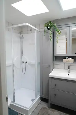 a white bathroom with a shower and a sink at Boshuisje De Eekhoorn in Lanaken