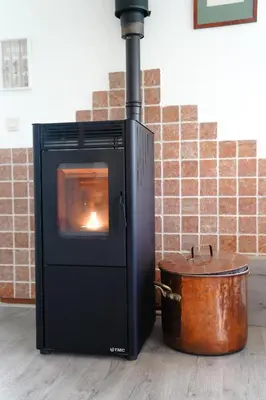 a stove with a pot in front of a brick wall at Boshuisje De Eekhoorn in Lanaken