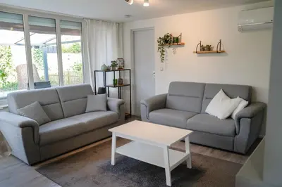 a living room with two couches and a coffee table at Boshuisje De Eekhoorn in Lanaken