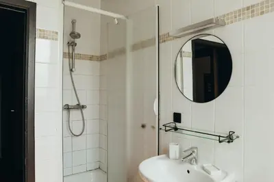 a bathroom with a shower and a sink and a mirror at Au pied du Pré by WelcHome in Verviers