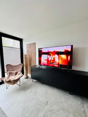 a living room with a large flat screen tv on a wall at Stylish Home near Maastricht Alicias house in Lanaken