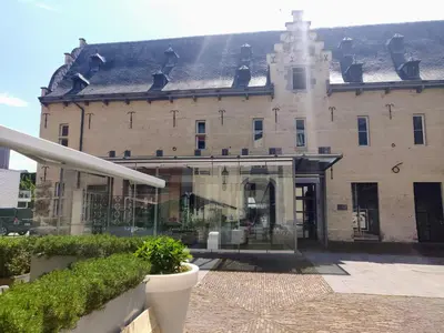 a large brick building with a glass entry way at KolMojen in Sint-Truiden