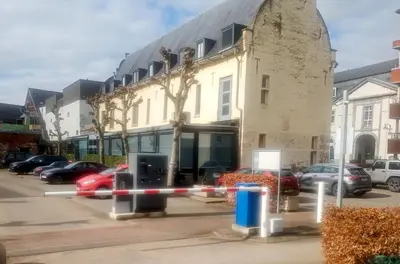 a building with cars parked in a parking lot at KolMojen in Sint-Truiden