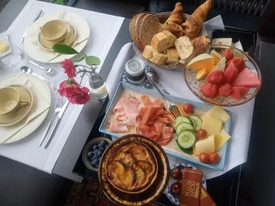 a table topped with a tray of food with fruit and bread at KolMojen in Sint-Truiden