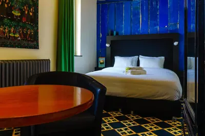 a bedroom with a bed with a wooden table and a tableablish at KolMojen in Sint-Truiden