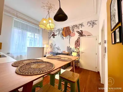 a dining room with a table and some chairs at Le cocon rose - Chic, proche Jardin botanique in Liège