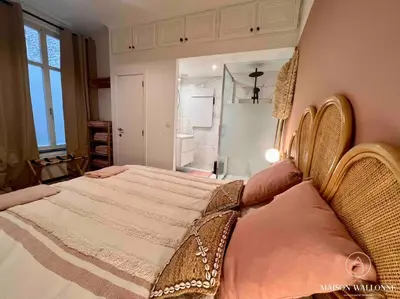 a bedroom with a large bed and a large window at Le cocon rose - Chic, proche Jardin botanique in Liège