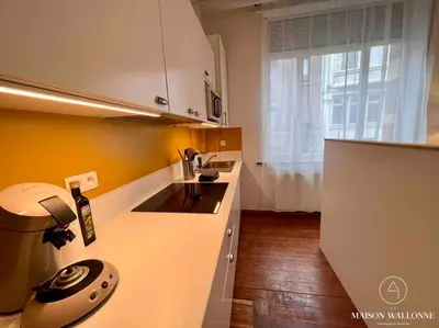 a kitchen with a phone on the counter at Le cocon rose - Chic, proche Jardin botanique in Liège