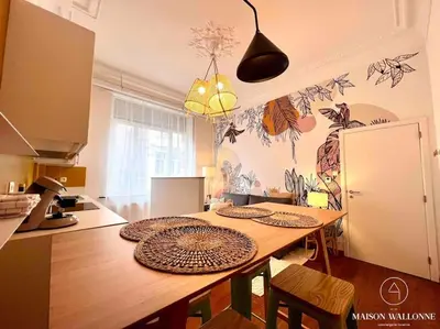 a kitchen with a wooden table with plates on it at Le cocon rose - Chic, proche Jardin botanique in Liège