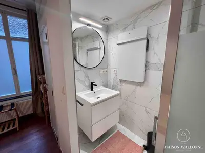 a white bathroom with a sink and a mirror at Le cocon rose - Chic, proche Jardin botanique in Liège
