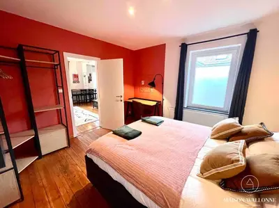 a bedroom with a large bed with red walls at Le Loft liégeois - Au coeur de la cité in Liège