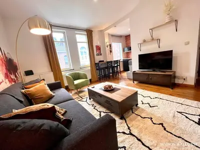 a living room with a couch and a tv at Le Loft liégeois - Au coeur de la cité in Liège