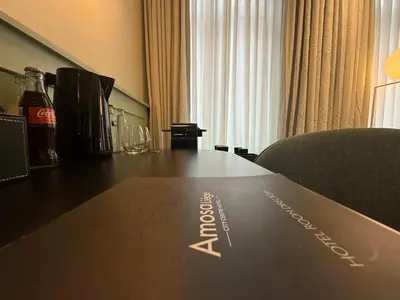 a table with a bottle of cocacola on top of it at Amosa Liège City Centre Hotel in Liège