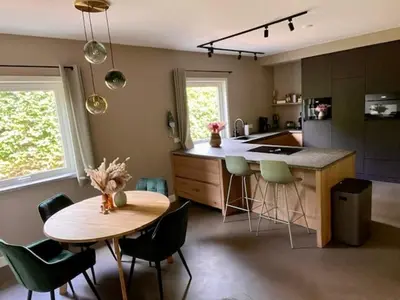 a kitchen with a table and a table and chairs at Villa Bosrijk in Lommel