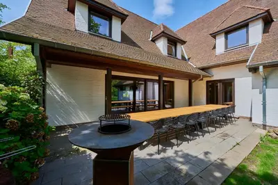 a patio with a table and chairs in front of a house at Villa Bosrijk in Lommel