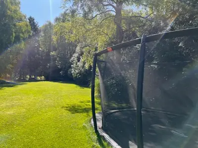 an open door to a field of green grass at Villa Bosrijk in Lommel