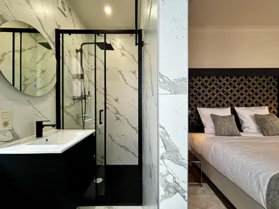 a bathroom with a bed and a sink and a mirror at Maison du Roi in Liège