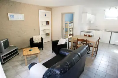 a living room with a leather couch and a table at Apartment 't Maanhof in Gingelom