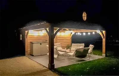a gazebo with chairs and a table in a yard at Looshof in Helchteren