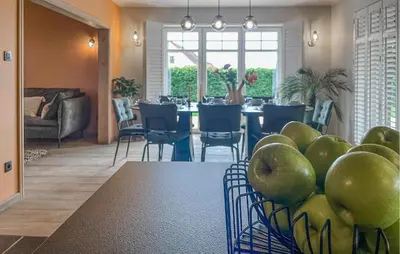 a dining room with a table with green apples in a basket at Looshof in Helchteren