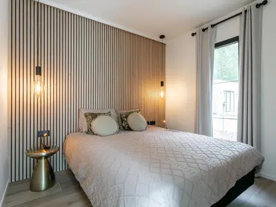 a bedroom with a bed and a large window at Thalor in Zutendaal