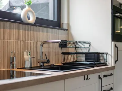 a kitchen counter with a sink and a microwave at Thalor in Zutendaal