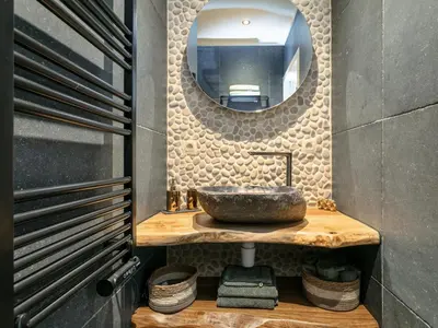 a bathroom with a stone sink and a mirror at Thalor in Zutendaal