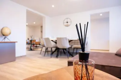 a vase with sticks in it sitting on a table in a living room at Stijlvol appartement met jacuzzi & sauna in Herk-de-Stad