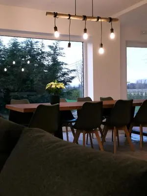a dining room with a table and chairs and a large window at Ten Velde - vakantiewoning 12 personen - sauna - bubbelbad in Hoeselt