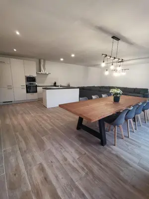 a kitchen and dining room with a wooden table and chairs at Ten Velde - vakantiewoning 12 personen - sauna - bubbelbad in Hoeselt