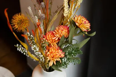 a white vase with a bunch of flowers in it at Hotel Het Menneke in Hasselt