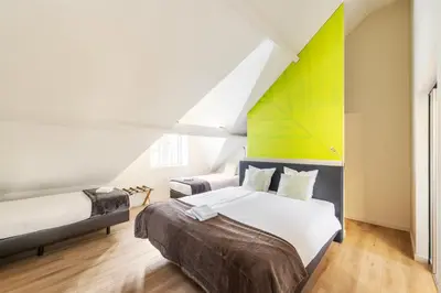 a bedroom with a bed and a yellow and white wall at Hotel Het Menneke in Hasselt